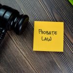 Concept of Probate Law write on sticky notes with gavel isolated on Wooden Table.